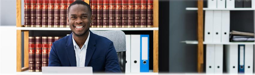 Photo of public administration professional working at a desk with legal books in the background