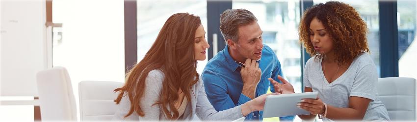 Business professionals discussing information on a tablet computer