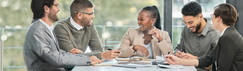 Public service professionals in a meeting discussing a project and smiling.